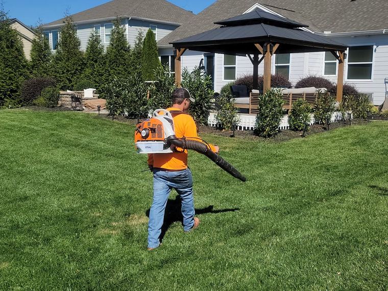 Fonseca crew member clearing a freshly cut lawn with a backpack blower